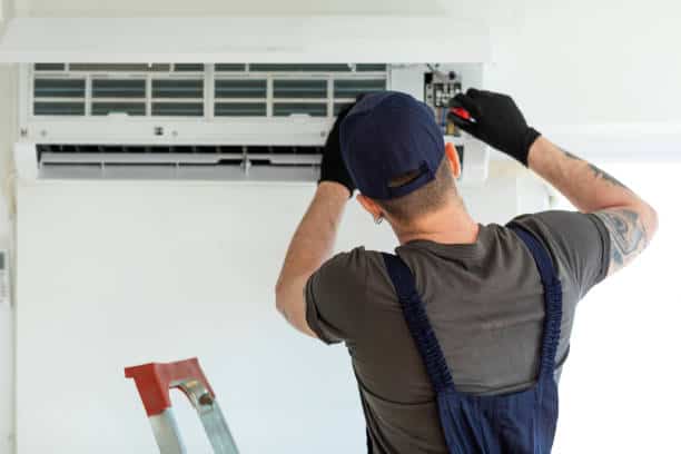 Professional HVAC repair technician servicing air conditioning unit in Orlando<br />
